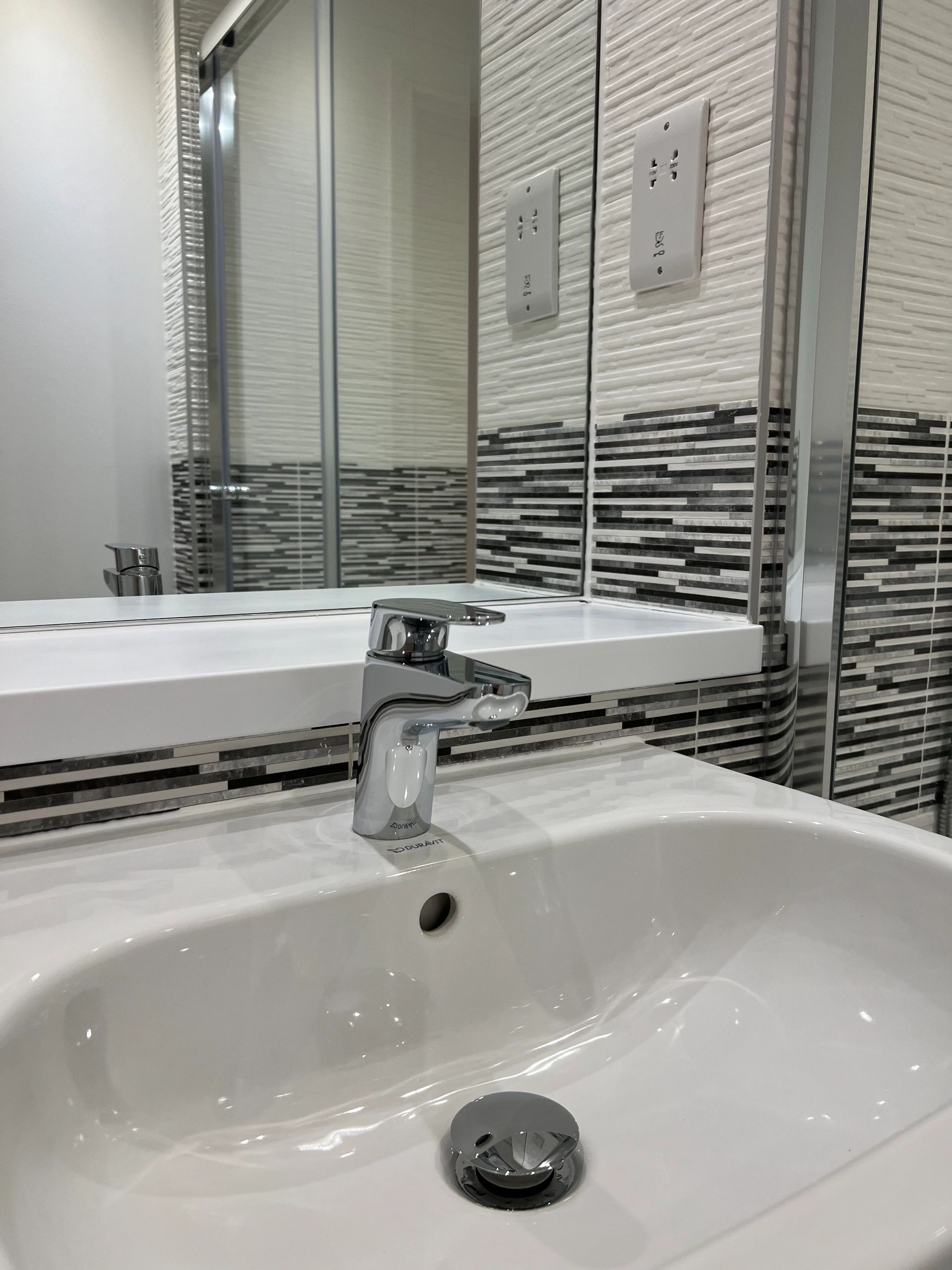 Close-up of a clean bathroom sink and chrome tap