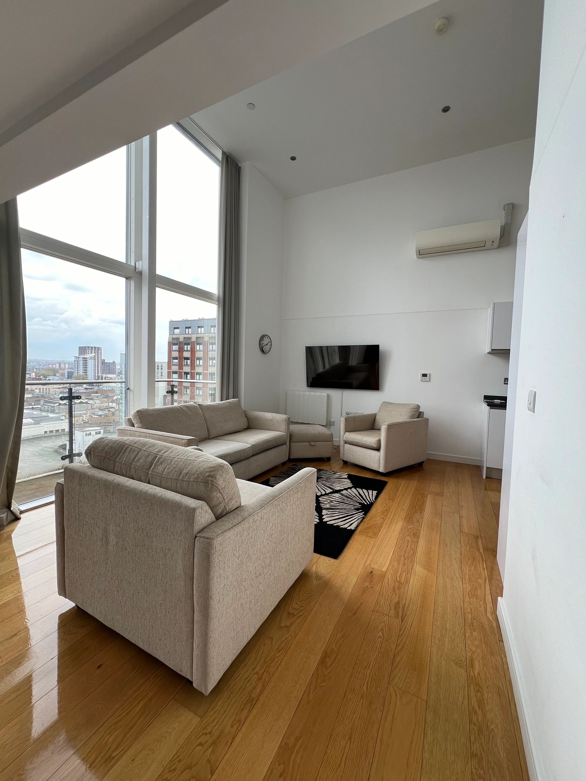 Clean modern living room with sofa and balcony doors