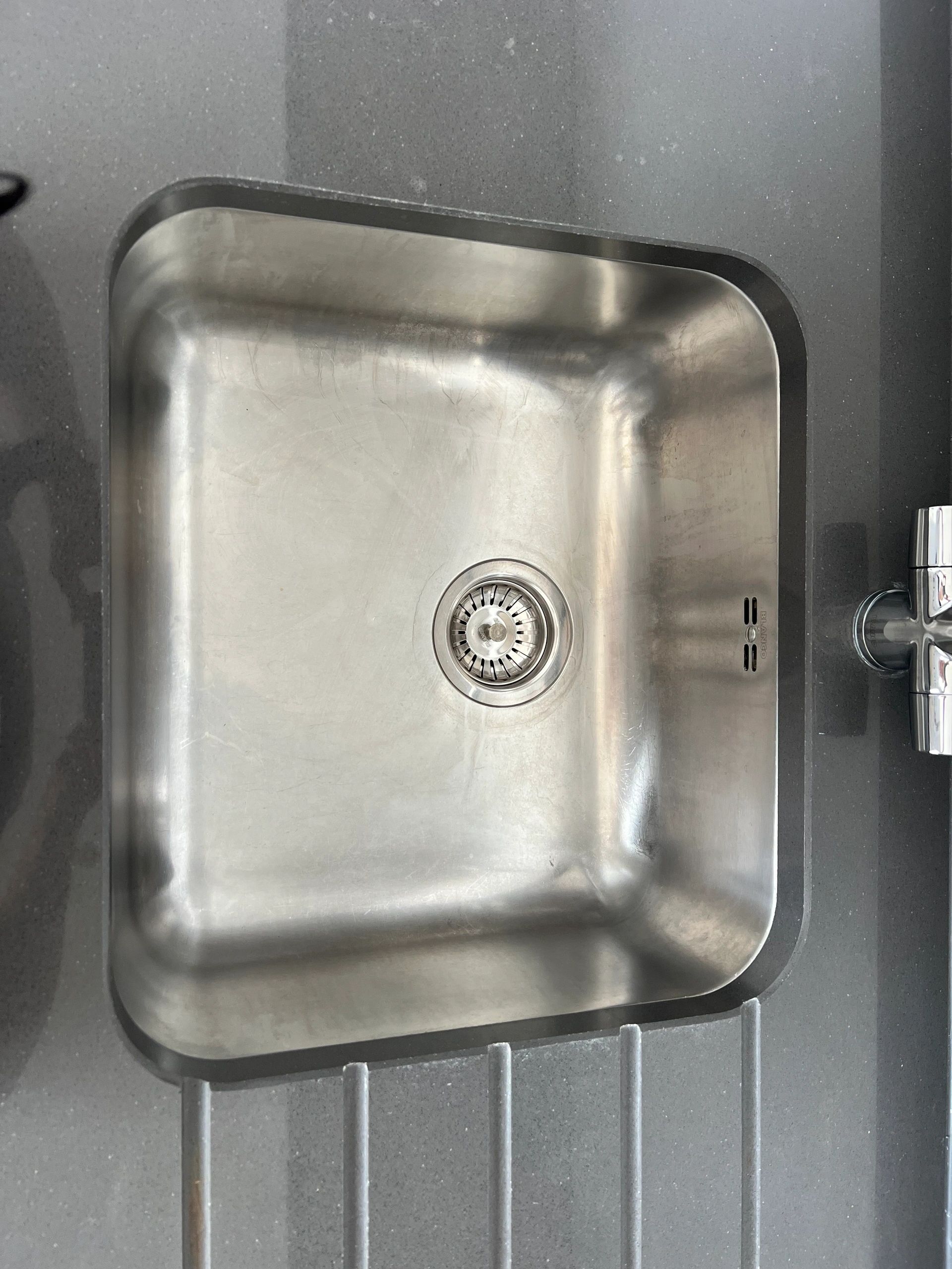 Close-up of a spotless stainless steel sink basin
