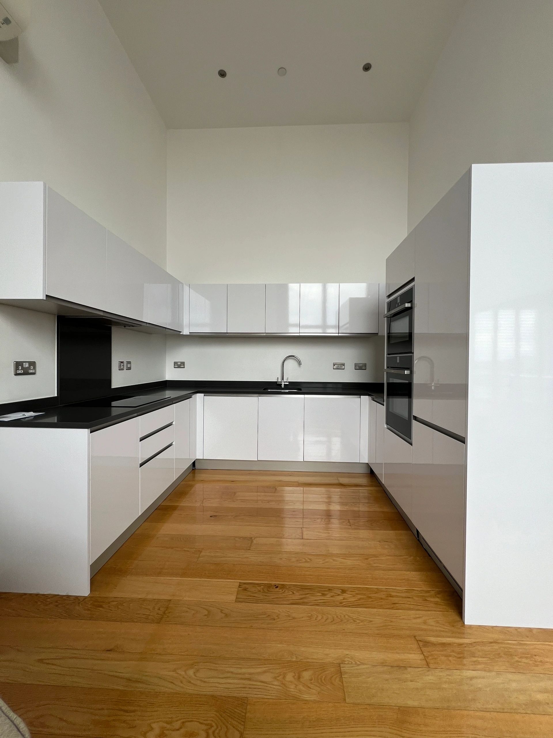 Bright white kitchen with clean countertops and wood floor